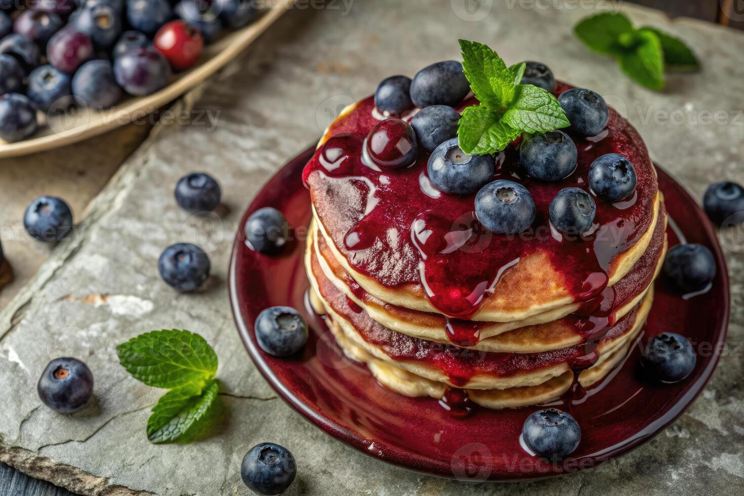 Stack of pancakes topped with berries and mint leaves. photo