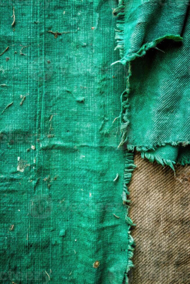 Worn green textured fabric with frayed edges for grunge effect photo