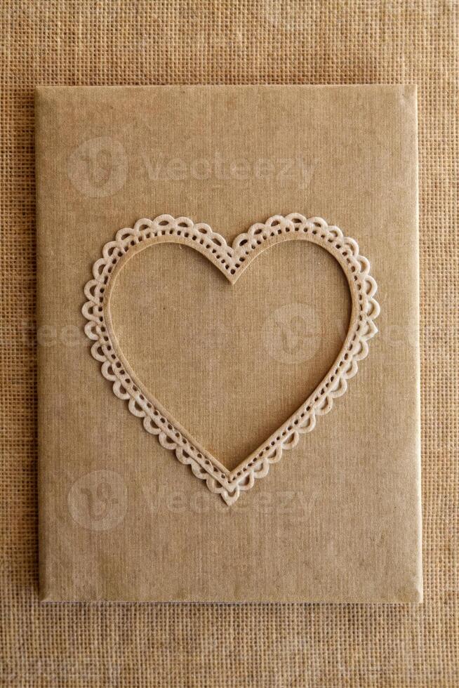 A heart-shaped lace detail on a textured fabric background. photo