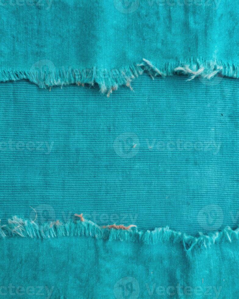 Vibrant turquoise fabric with frayed edges on display. photo