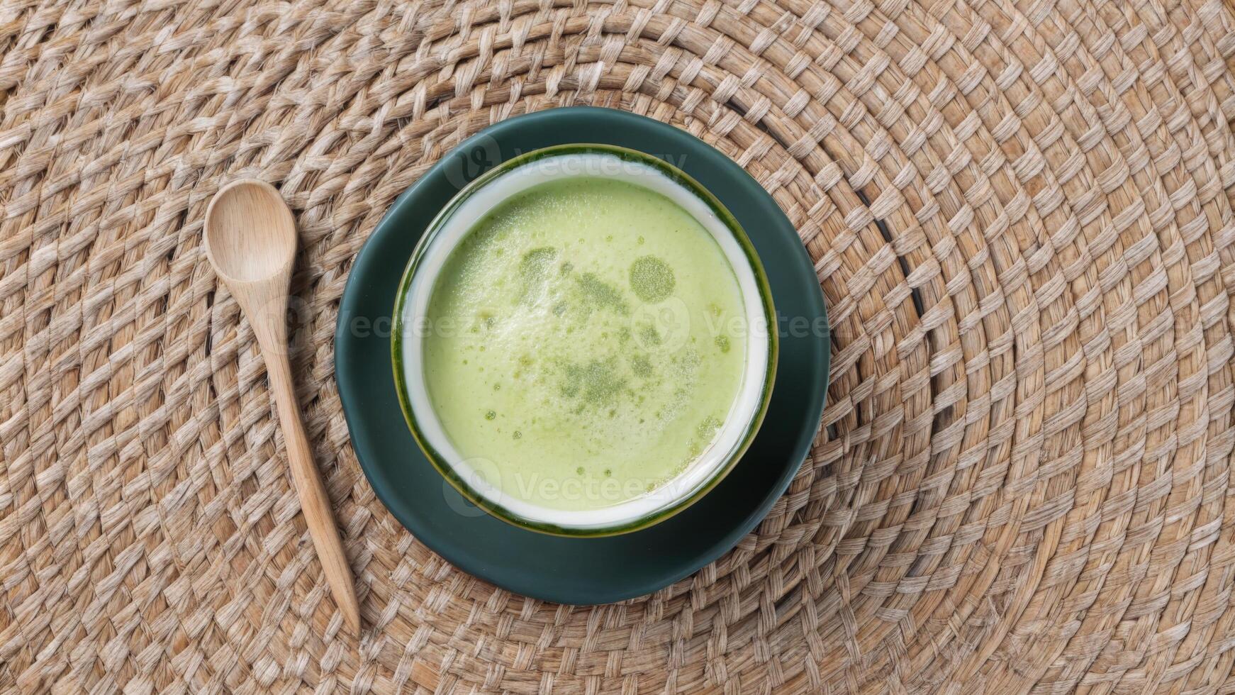 Fresh Green Matcha Tea in Black Ceramic Bowl with Wooden Spoon photo