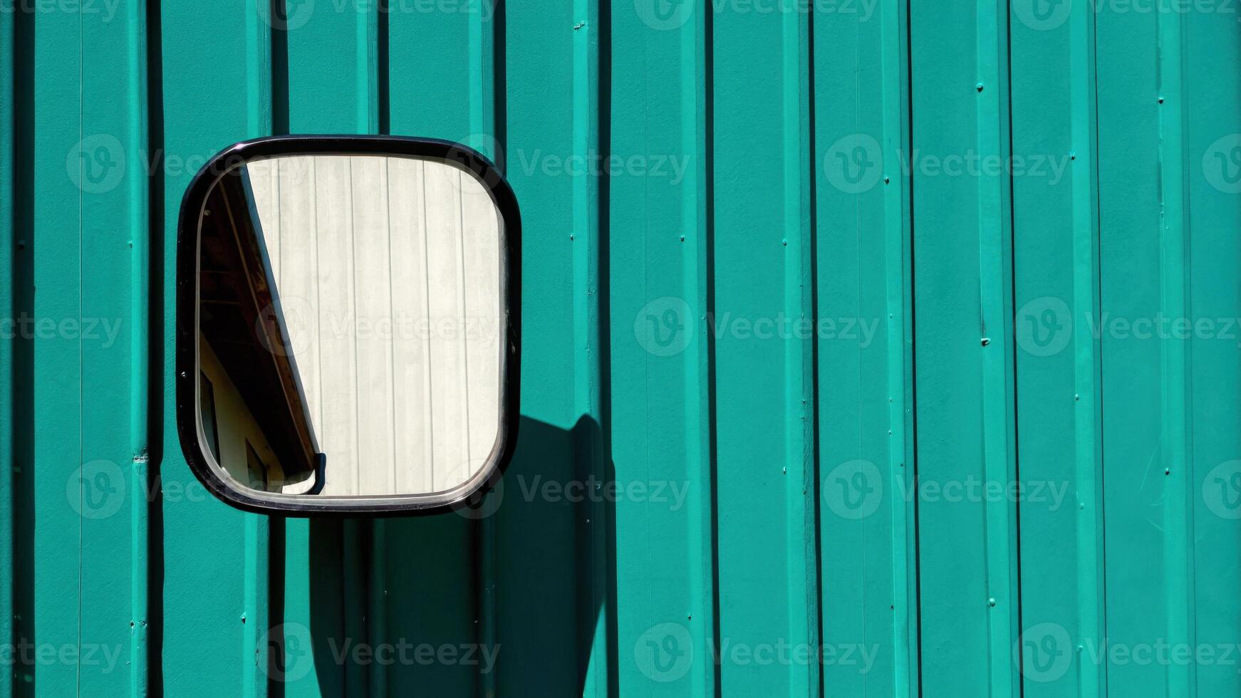 Teal Metal Wall Reflecting a Side Mirror Accent photo