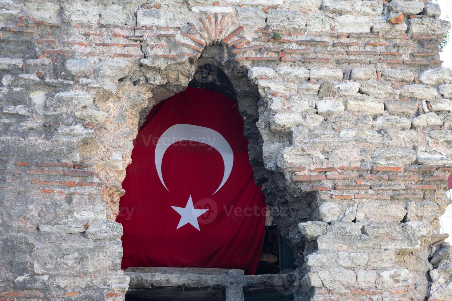 Turkish flag displayed in ancient stone wall opening photo