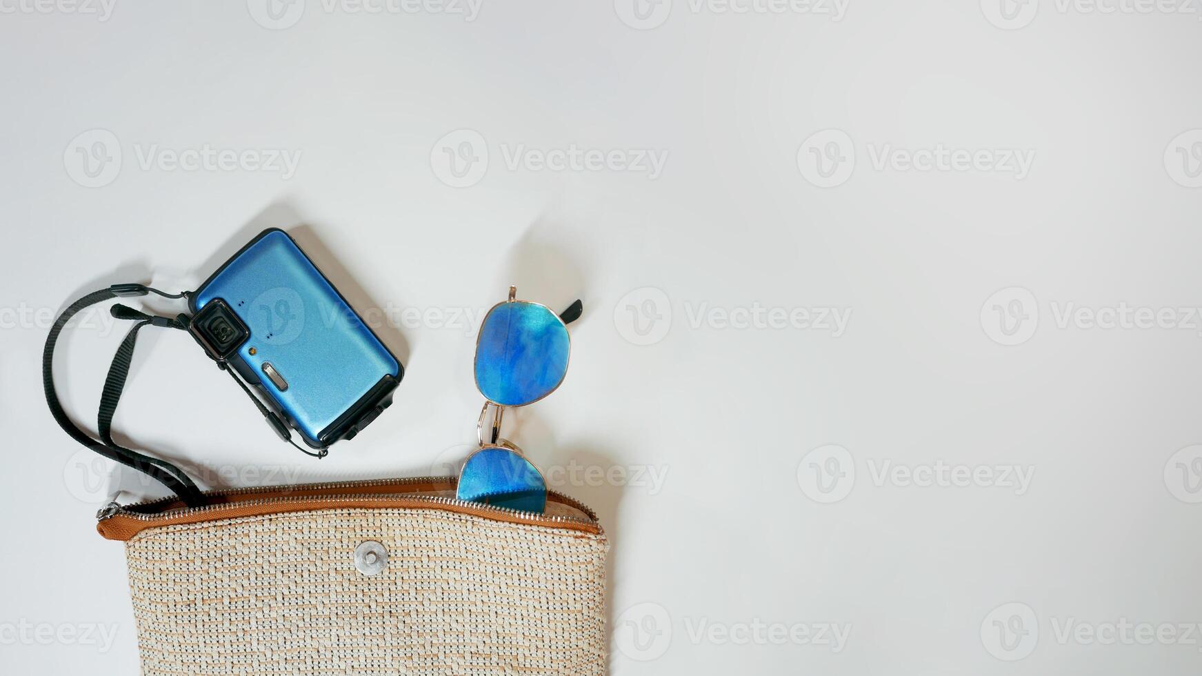 Summer vacation mood layout lifestyle spa or wellness concept with beach accessories and copy space. Top view flat lay background, including beach bag, sunglasses, photo camera