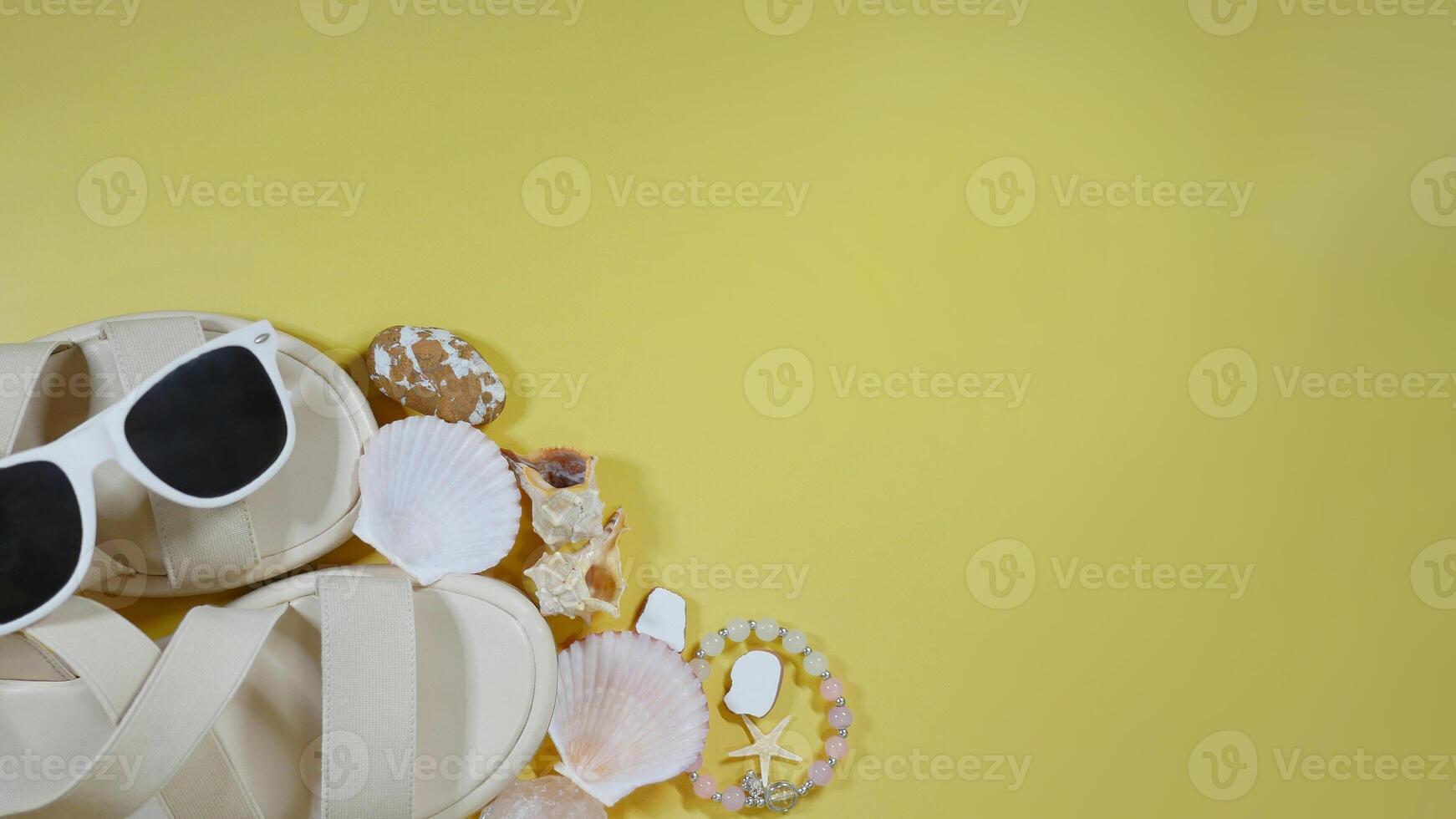 Summer travel vacation mood layout lifestyle spa or wellness concept with beach accessories and copyspace. Top view flat lay background, including sunglasses, sandals, seashells and pebbles photo