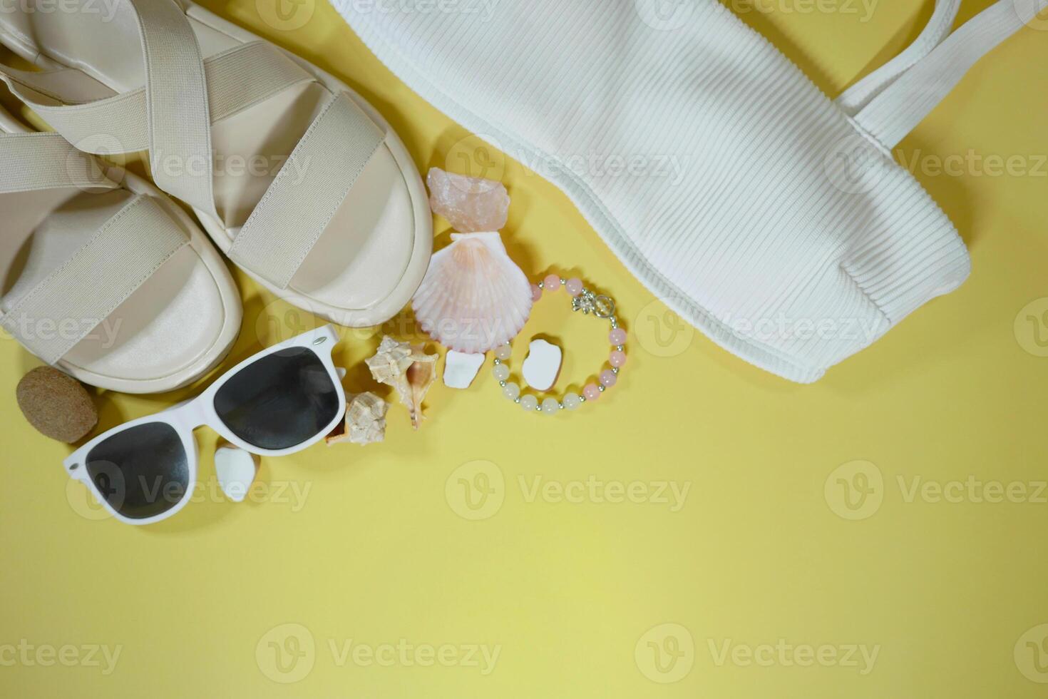 Summer travel vacation mood layout lifestyle spa or wellness concept with beach accessories and copy space. Top view flat lay background, including sunglasses, swimsuit, sandals photo