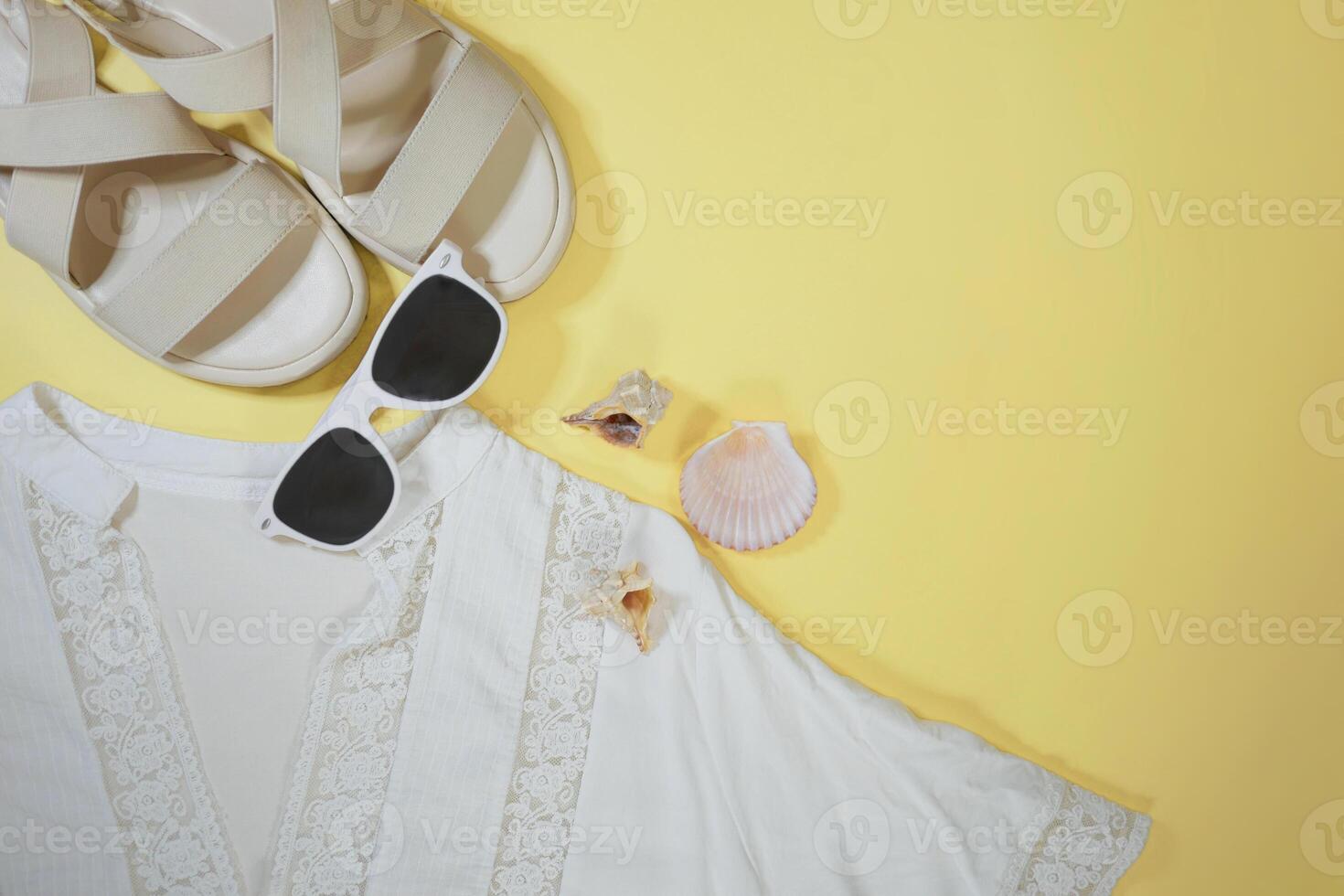 Summer travel vacation mood layout lifestyle spa or wellness concept with beach accessories and copy space. Top view flat lay background, including sunglasses, sandals and white tunic photo