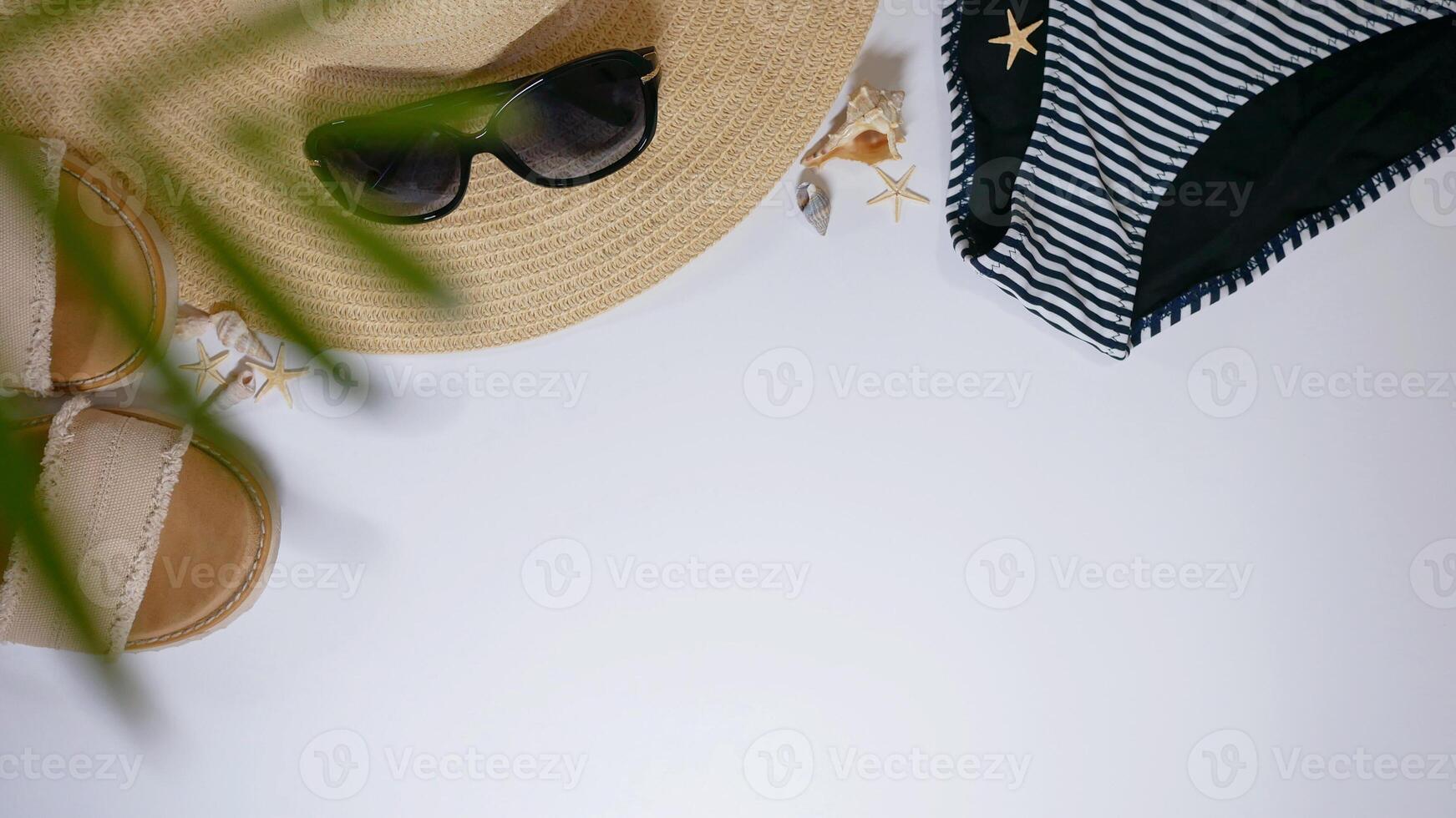 Summer travel vacation mood layout lifestyle spa wellness concept with beach accessories and copy space. Top view flat lay background, including strawhat, sunglasses, swimsuit, seashells and pebbles photo