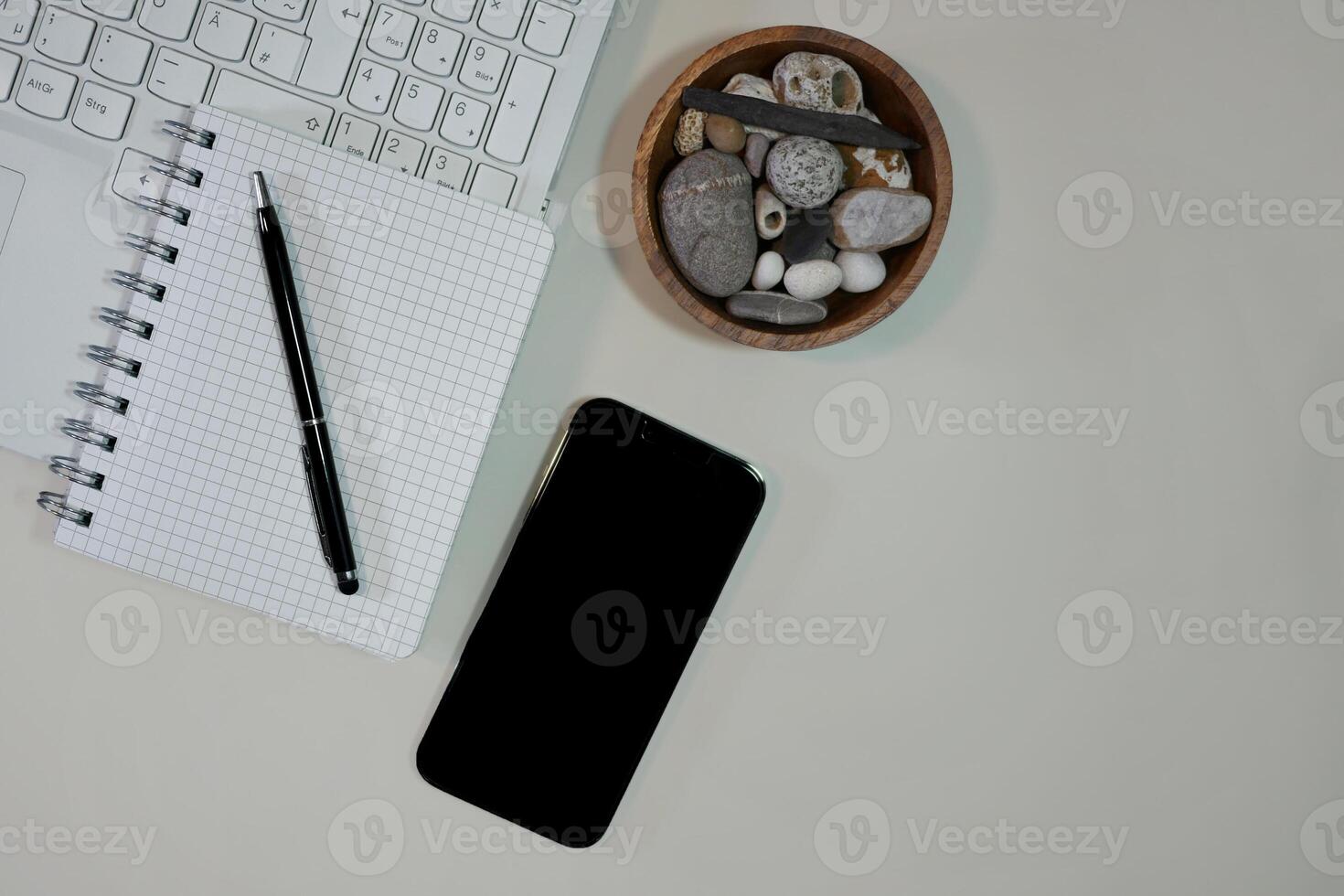 Flat lay on white background top view with copy space. Computer keyboard, notebook and smartphone. The concept of business, study or IT photo