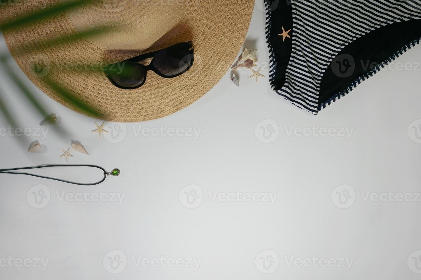 Summer travel vacation layout lifestyle spa wellness concept with beach accessories and copy space. Top view flat lay background, including straw hat, sunglasses, swimsuit, seashells and pebbles photo