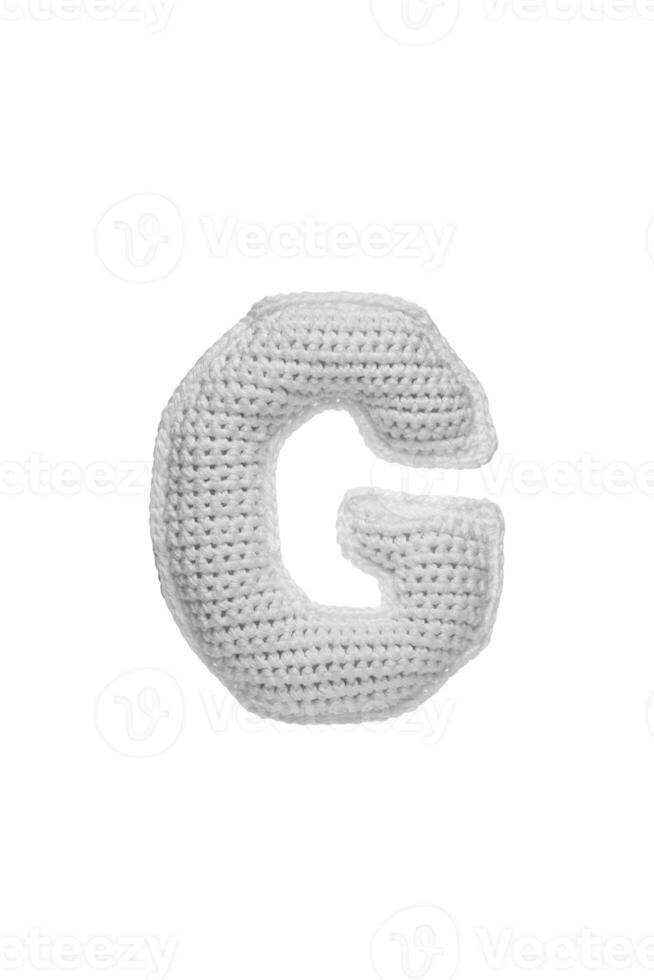Handmade crocheted letter G in light grey yarn, isolated on white background photo