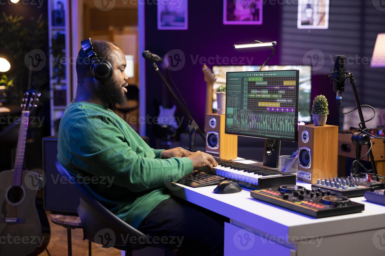 Sound designer pressing keys of electronic midi controller and composing new track, adjusting volume levels on pre amp knobs. Artist producing music on piano synthesizer, mixing sounds. photo