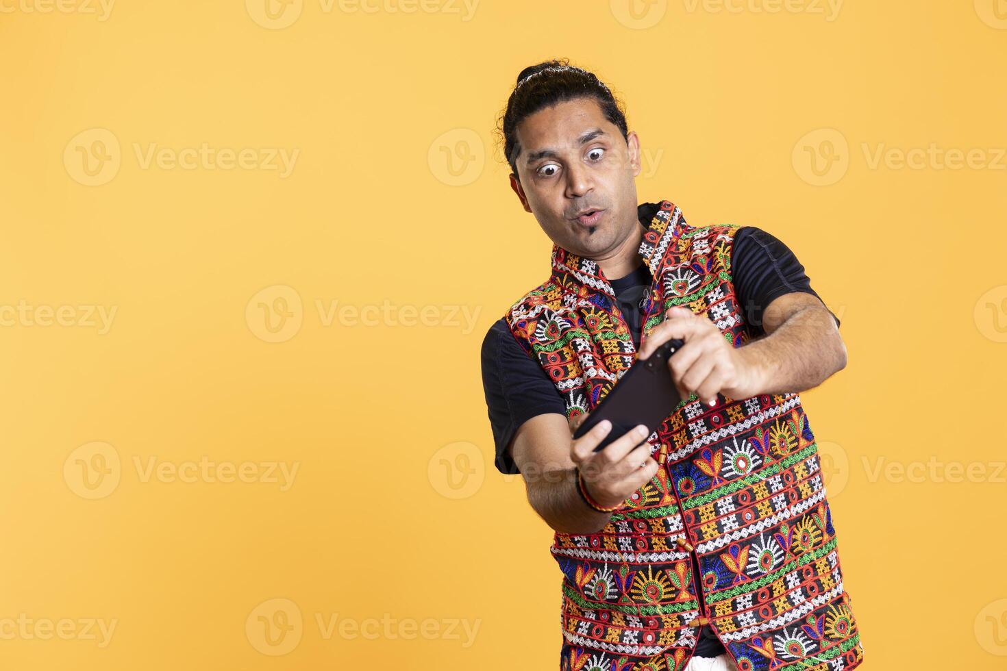 Man having surprised look on face after being defeated while playing videogames on smartphone. Person having shocked facial expression after being beaten by other players, studio background photo