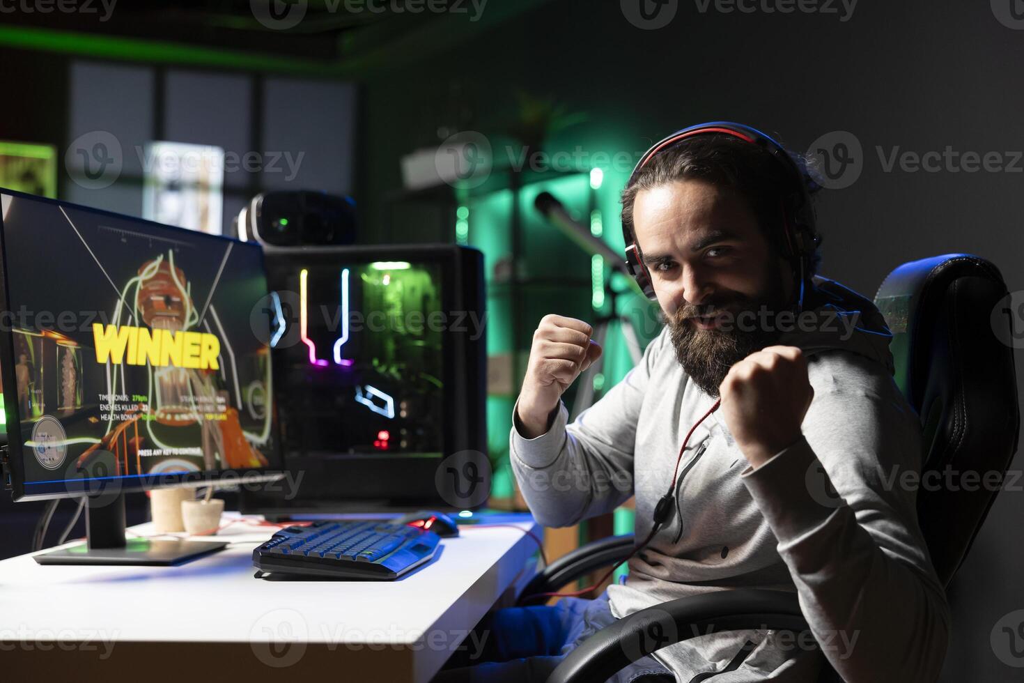 Exulting gamer excited after winning level in first person shooter, killing all enemies. Euphoric player celebrating, manifesting himself after being victorious in videogame photo