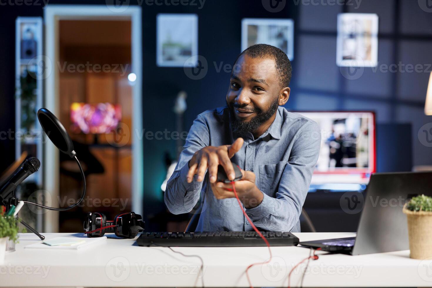 BIPOC internet show host filming review of newly released gaming led lights mouse in personal studio. Media star giving viewers feedback about computer peripheral performance photo