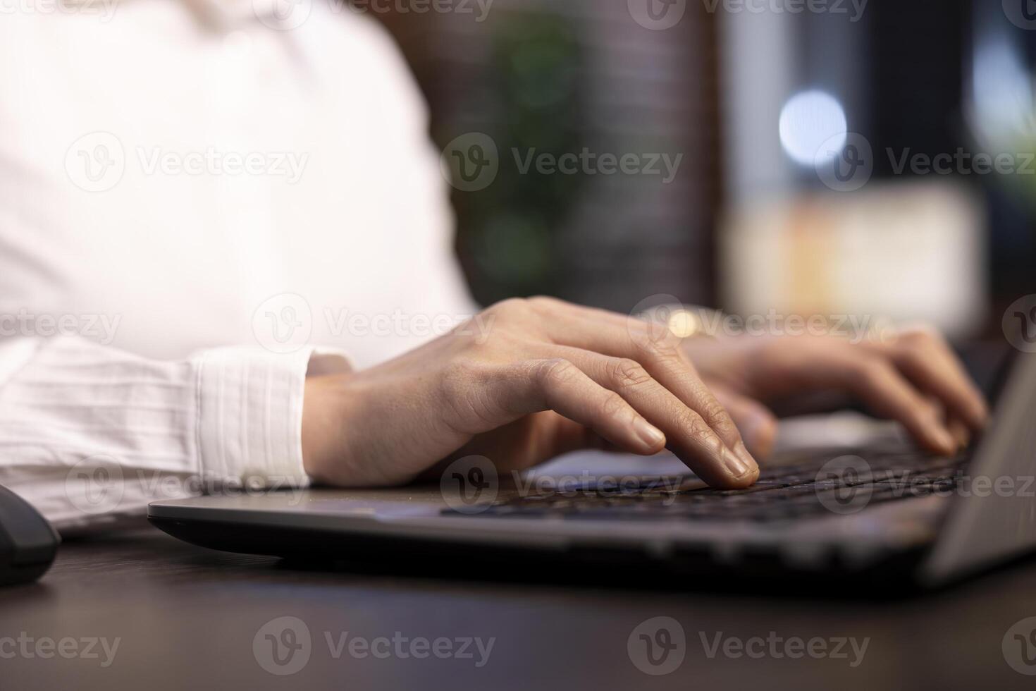 Female employee typing vital information on personal computer in office, with selective focus on her fingers to emphasize the precision involved in her task. Closeup of a person using laptop keyboard. photo