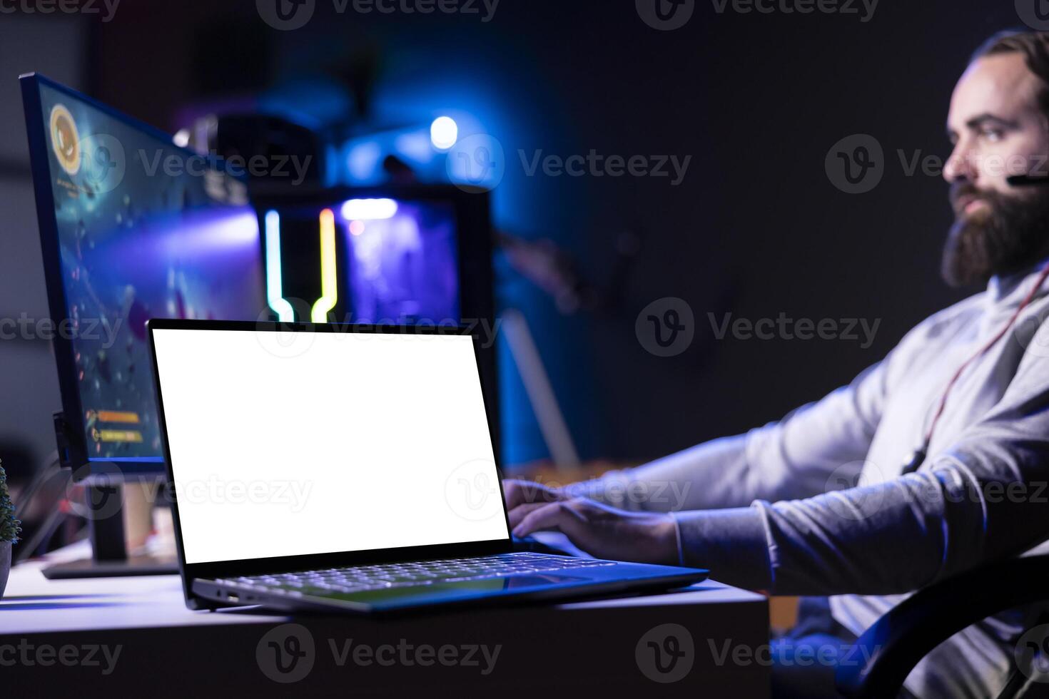 Isolated screen laptop next to man using gaming keyboard to play spaceship flying singleplayer game. Mockup notebook device and gamer navigating with spacecraft in galaxy, shooting at asteroids photo