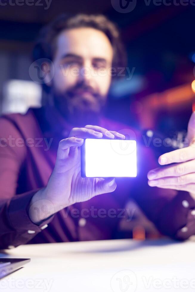 Close up shot of mini led lights, reviewed by tech guru filming technology videos. Focus on filming equipment shown by online star in blurry background to subscribers, talking in mic photo