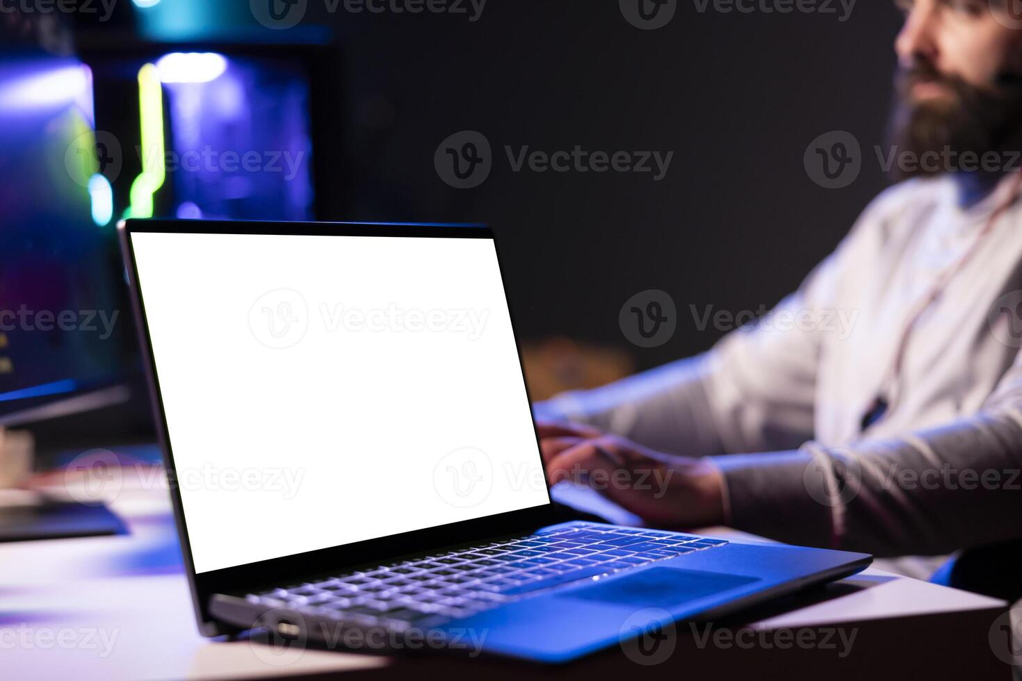 Close up of mockup laptop next to man playing videogames in front of subscribers during livestream, defeating enemies. Pro gamer streaming game, wearing headphones, using isolated screen notebook photo