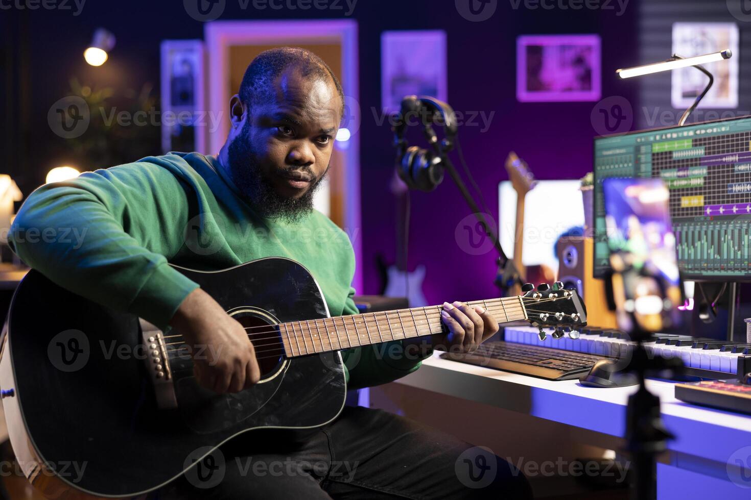 Professional composer teaching guitar lessons online on master class, recording himself playing acoustic instrument accords and explaining notes for a tutorial. Young musician making vlogs. photo