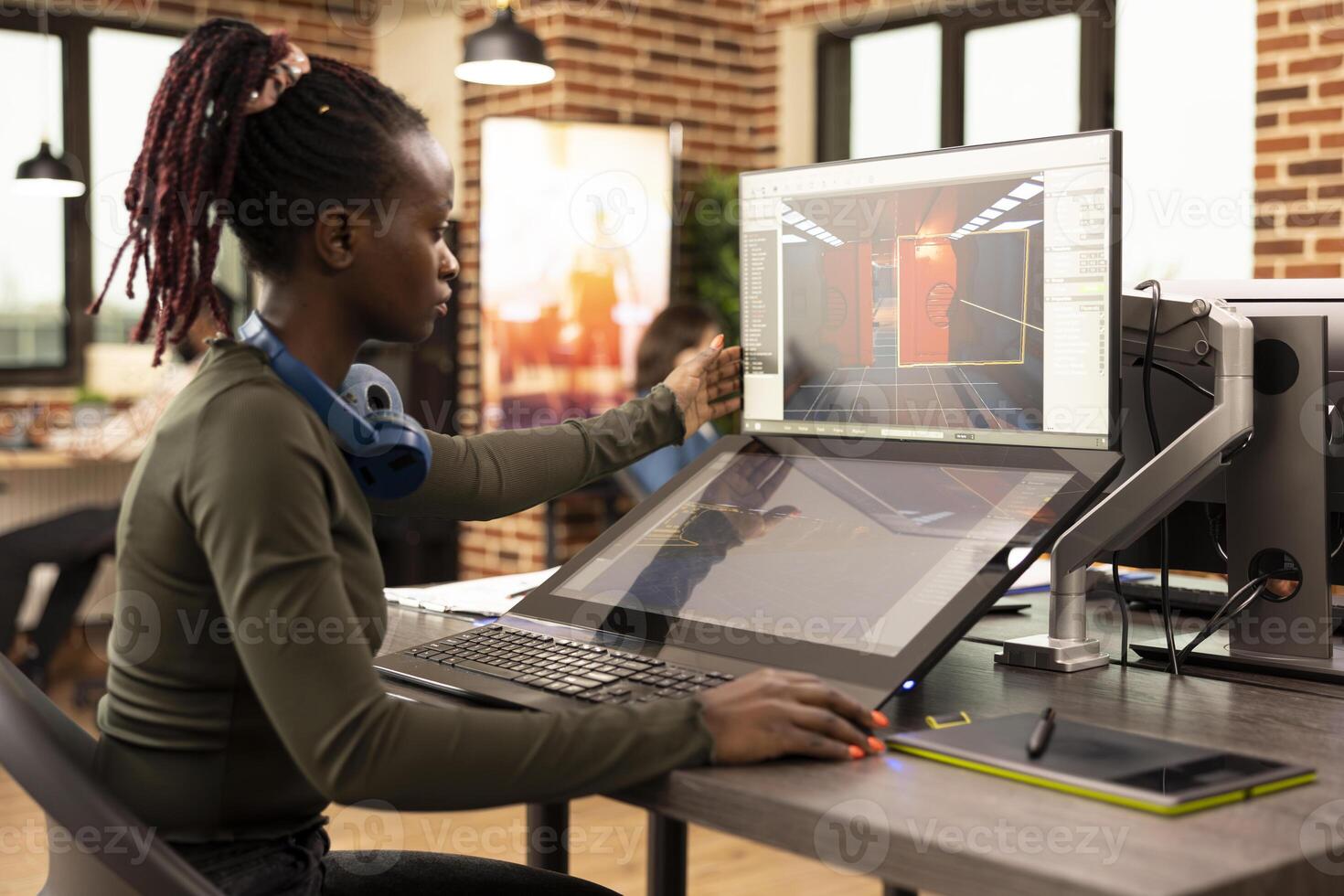 African American digital artist analyzing a creative project on desktop screen in a startup company. Black female employee looking at screen, working on her designs at the production department office photo