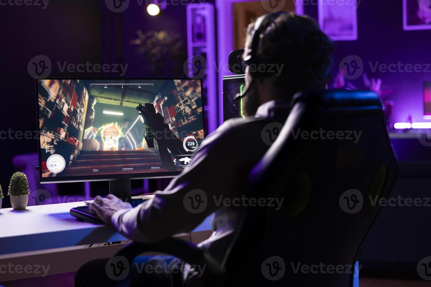 Player wearing headphones reaching final mission in FPS videogame, battling flying robots shooting laser bullets at him. Gamer playing game, fighting final boss, using headset to be immersed photo