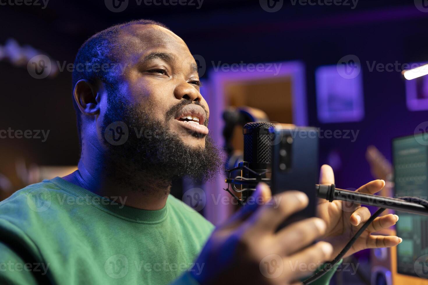 Artist producer performing acoustic version on his new track, editing the tunes with mixing console in home studio. Young singer recording songs on microphone, creative lyrics. Close up. photo