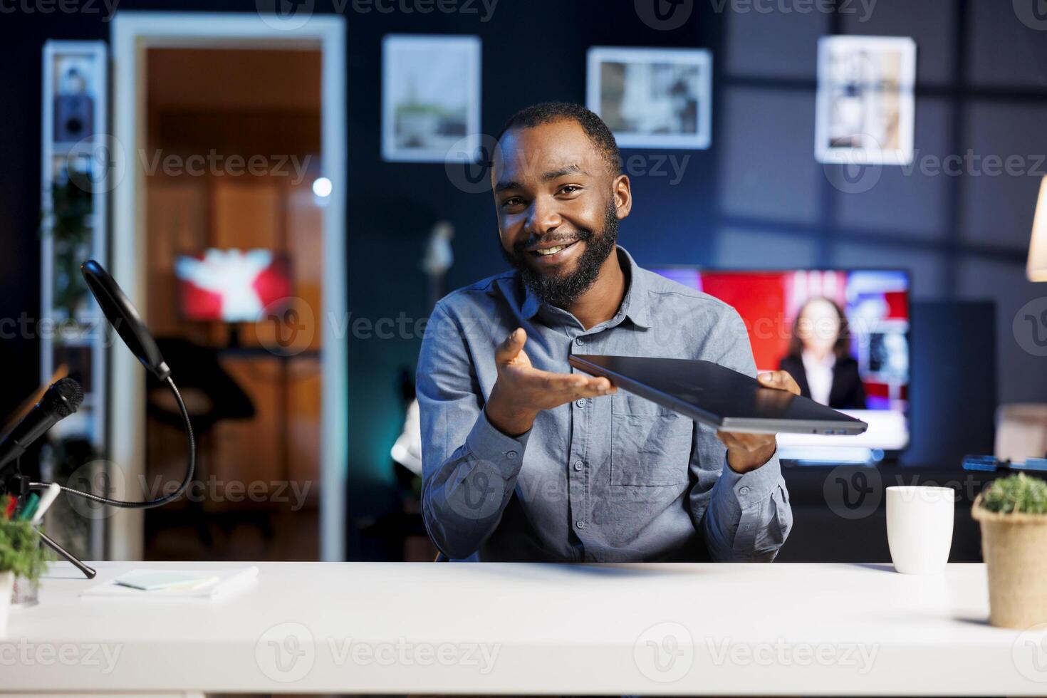 Content creator playing around with notebook device while doing review in personal studio to see if price is justified. Technology guru showcasing gaming laptop features to audience photo
