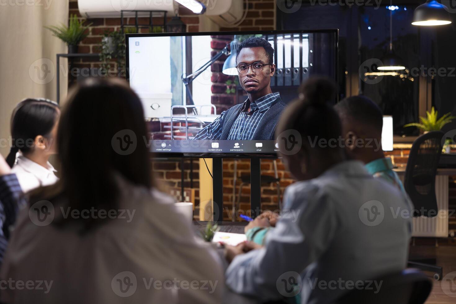 Businessman on digital monitor in virtual meeting with colleagues. Black male entrepreneur shares insights and contributes to brainstorming session on marketing strategies during videoconference call. photo