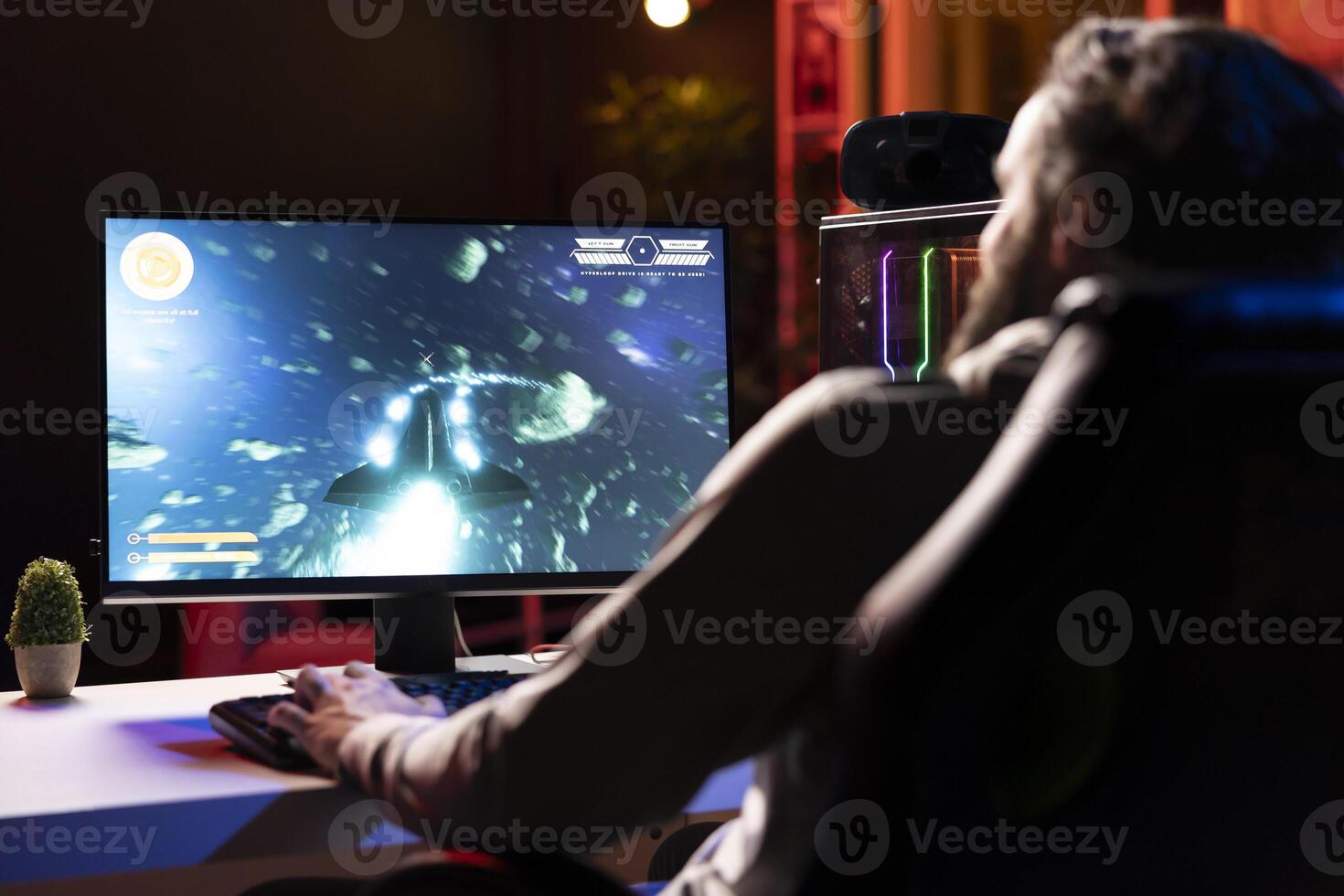 Man having fun shooting asteroids in spaceship flying game with overlay HUD showing health, fuel, ammo bars and minimap. Gamer navigating universe in simulation game, gaming on computer photo