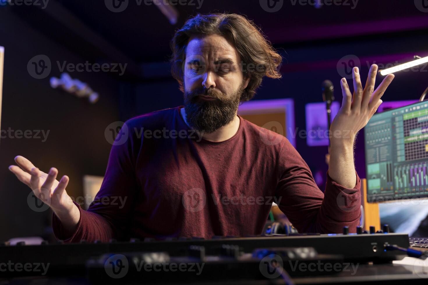 Musician feeling clueless and uncertain while he plays piano notes, trying new midi controller combinations to compose a song. Artist shrugging and being unsure about his song verses. photo