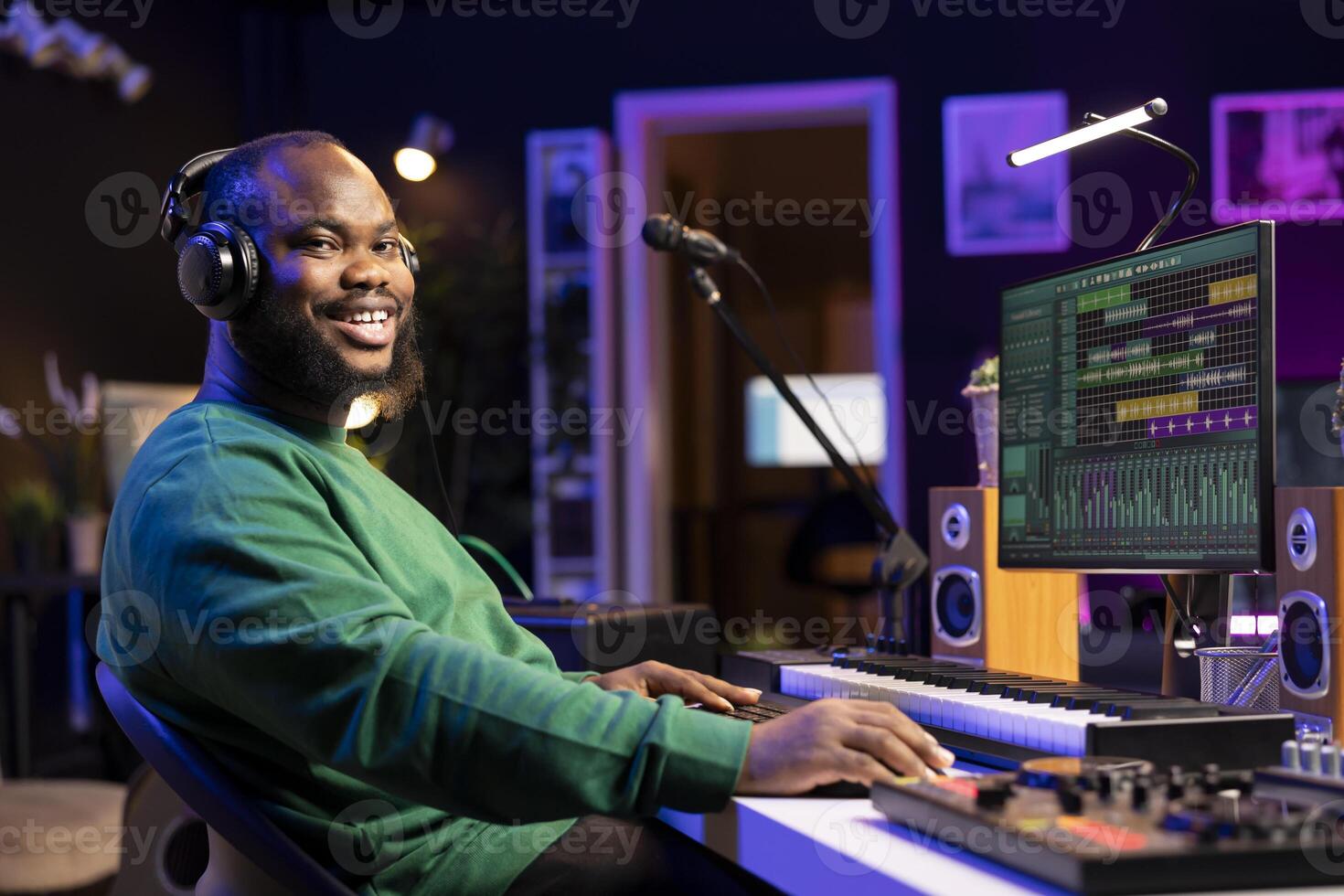 Portrait of skilled sound designer working in his home studio, adjusting volume levels on mixing console to edit old audio files. Music producer composing soundtracks on professional software. photo