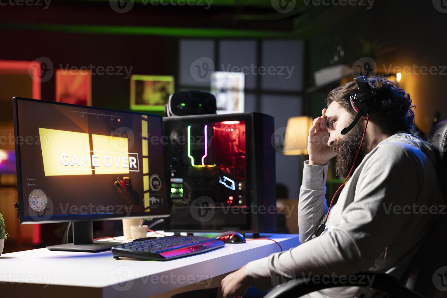 Sad person feeling upset after losing internet competitive multiplayer videogame match. Depressed gamer feeling down after being defeated in videogames, seeing game over message photo