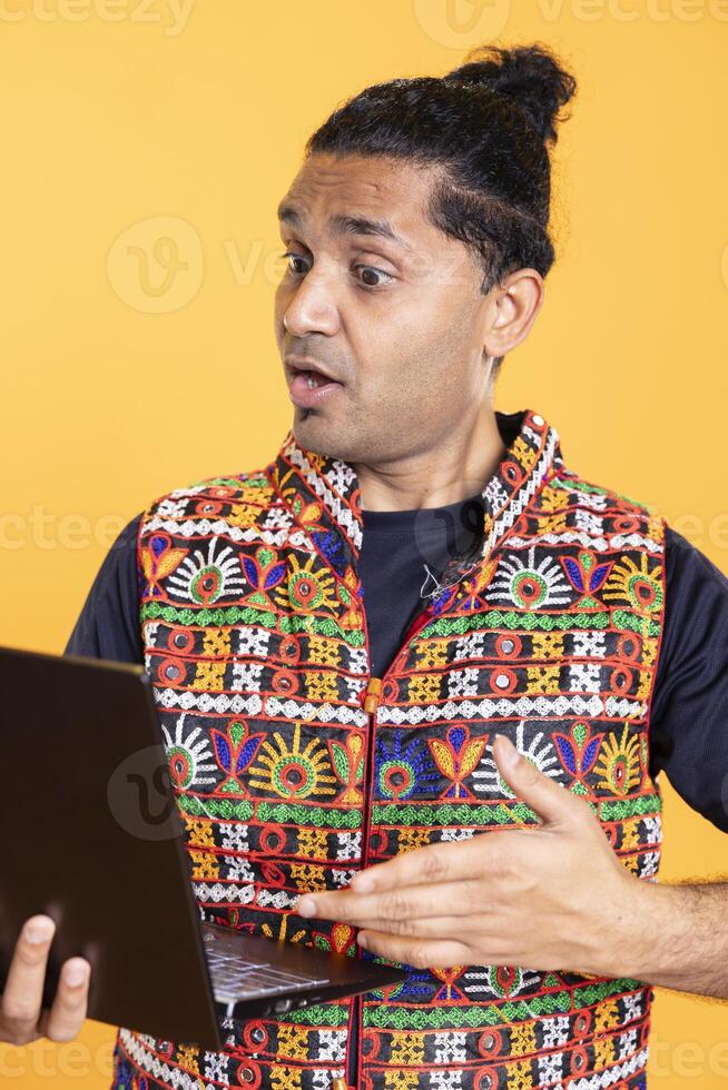 Stupefied person gasping after seeing error message on laptop screen while doing job tasks, studio background. Employee feeling speechless after receiving confusing decision on mail photo