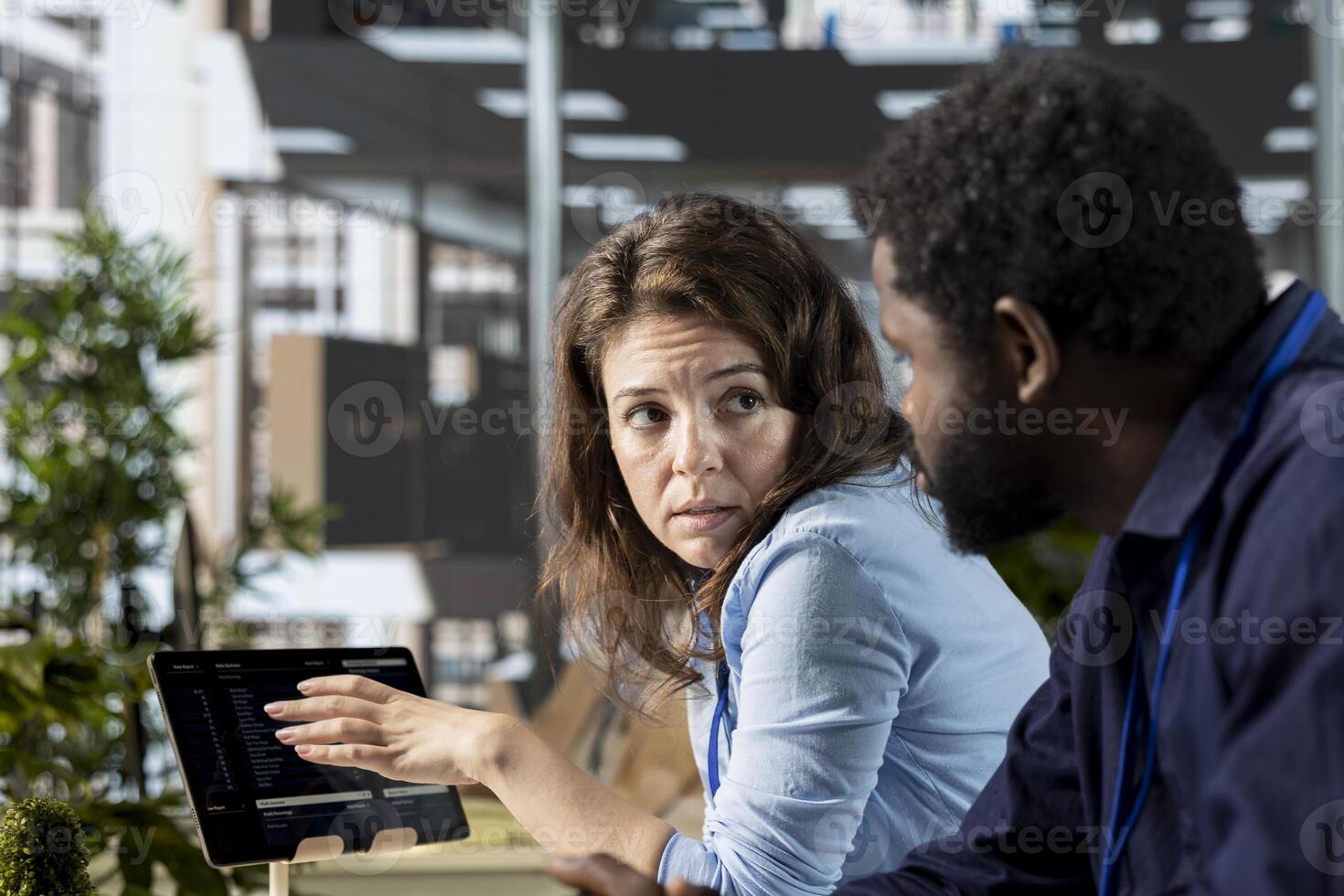 Diverse workmates team collaborating to review company numbers, creating an analysis to achieve business objectives. Two employees reviewing data analytics for a briefing report. photo