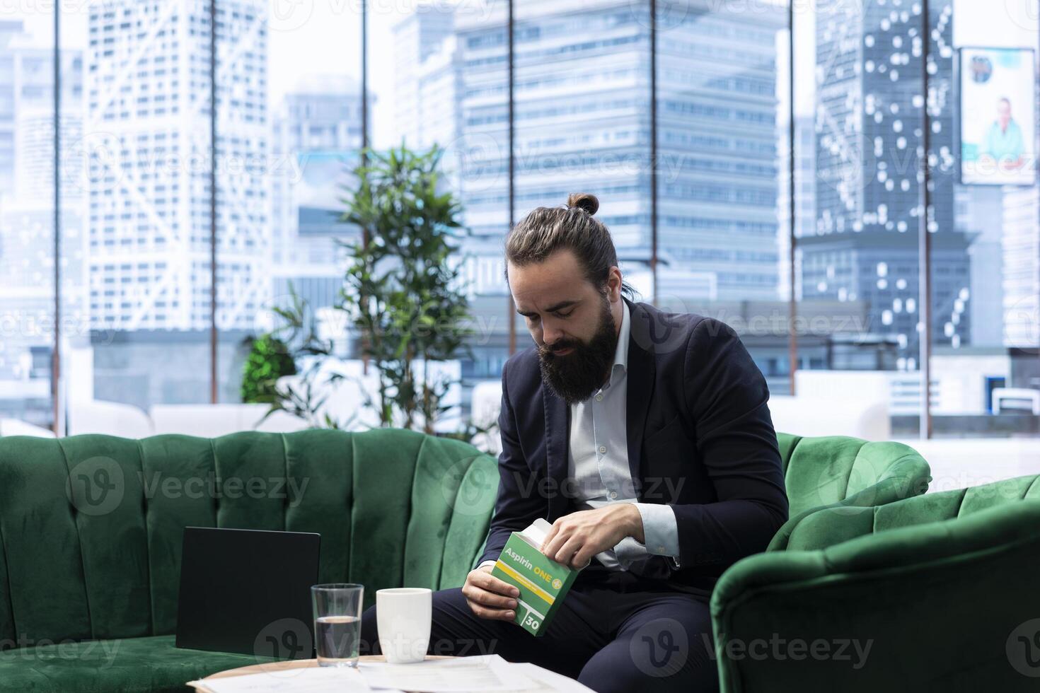 Concerned CEO taking an aspirin to ease the headache due to stress, feeling a discomfort and using painkillers. Tired uncomfortable boss deals with a migraine, burnout and tension. photo