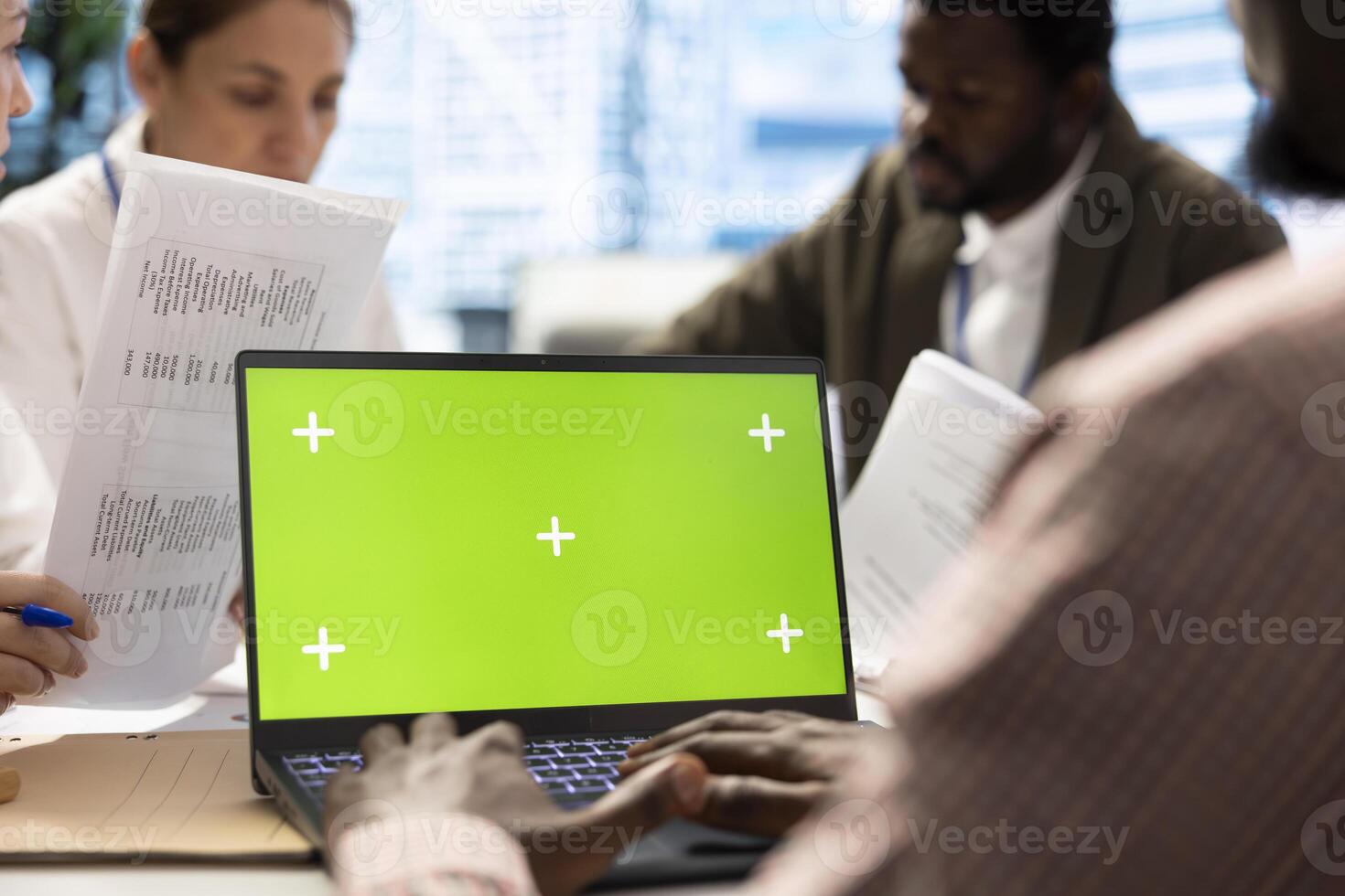 Business associates in a meeting using isolated chroma key display, working on resource allocation plans to increase profit. Team of corporate employees in a project briefing. Close up. photo