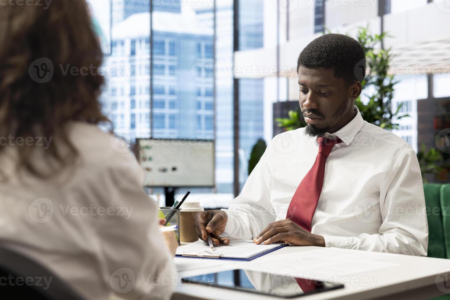 Human resources employee reviewing candidate resume while asking questions about qualifications. Man at interview proving skills, showcasing expertise and enthusiasm for job opportunity photo