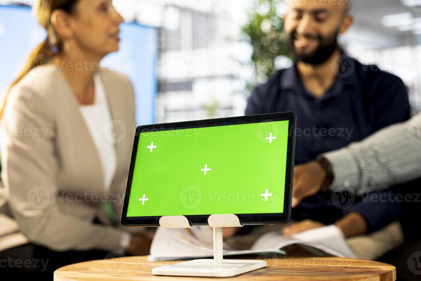 Focus on isolated screen tablet next to employees implementing business strategies to improve operational efficiency. Close up of mockup device next to office workers in blurry background photo