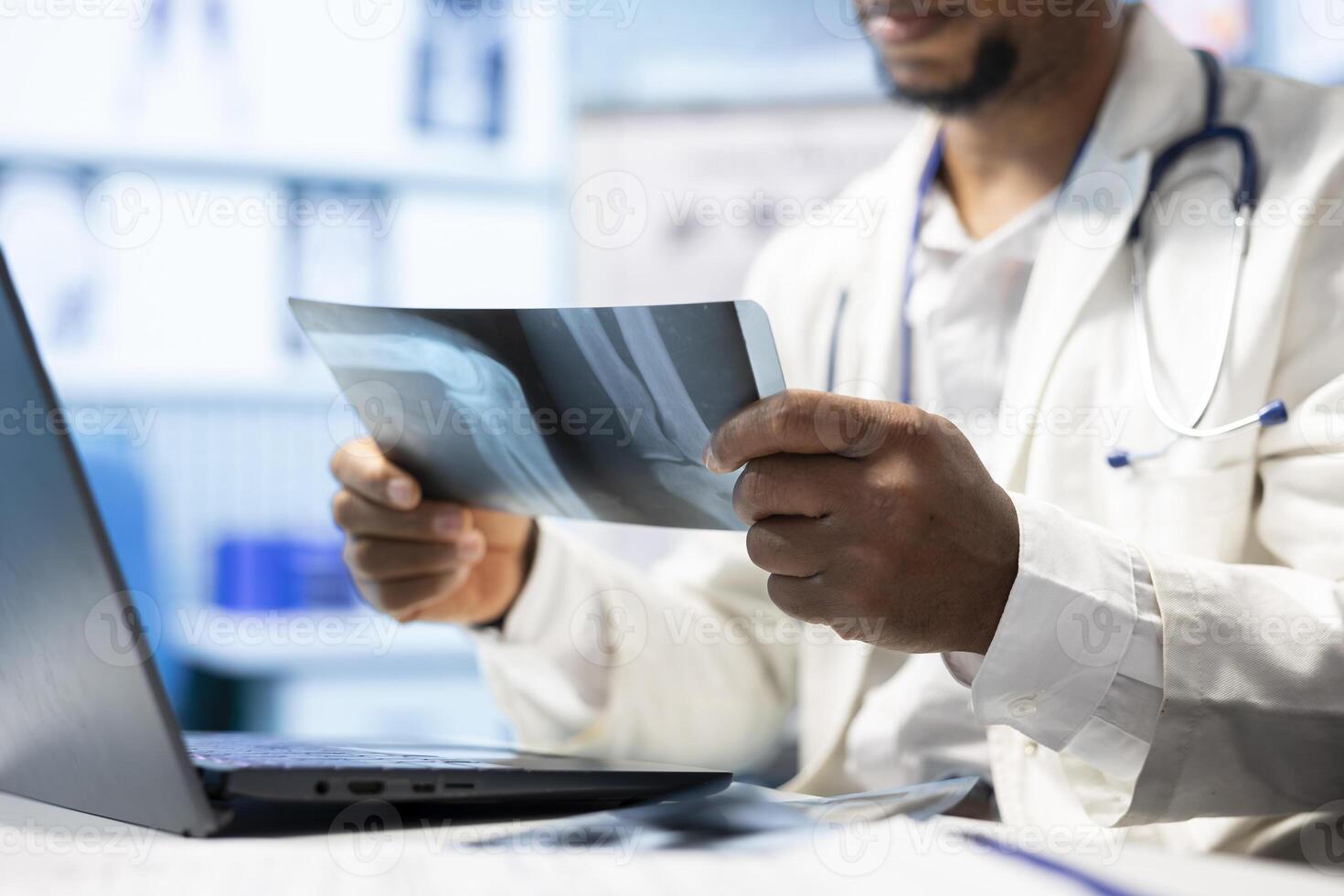 African american doctor analyzing radiography test results for recovery plan, consulting healthcare records and x ray scans for the right diagnosis. Radiology expert at private clinic. Close up. photo