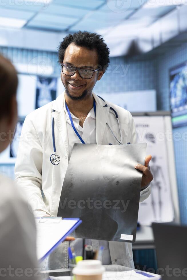 Doctors meeting in cabinet to discuss x ray scans results for a treatment plan, healthcare expertise and radiography tests for effective disease prevention through collaborative teamwork. photo