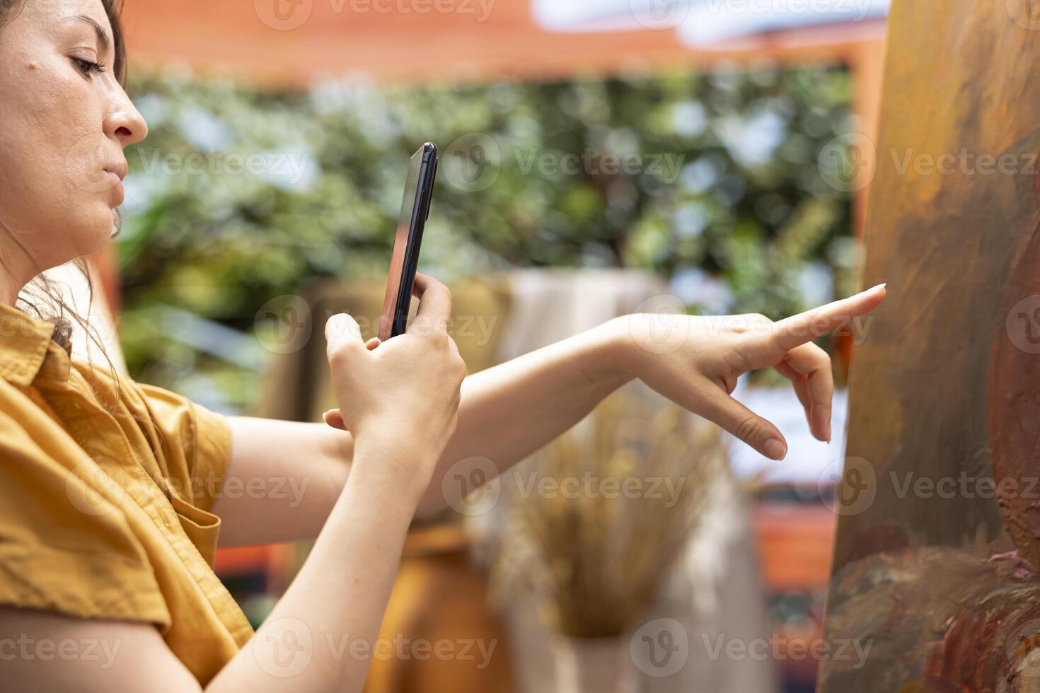 Woman artist recording a vlog to show her skill and painting techniques, creating a tutorial about inspiration in creating a rustic masterpiece. Painter does online painting lessons. photo