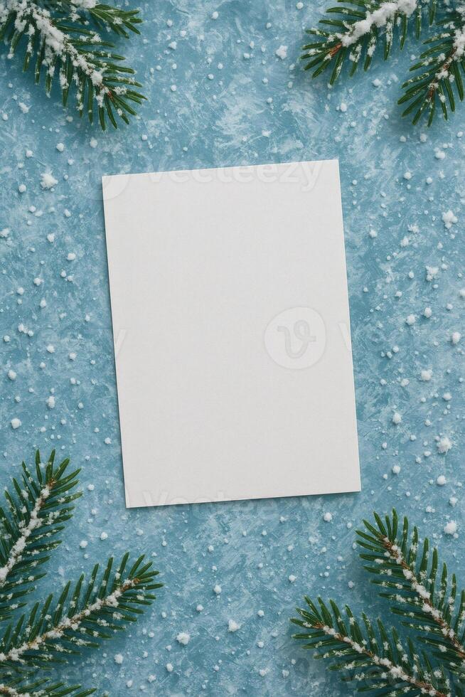 Blank white card on a winter background with snow and pine branches, perfect for holiday greetings or invitations. Copy space for your text. photo
