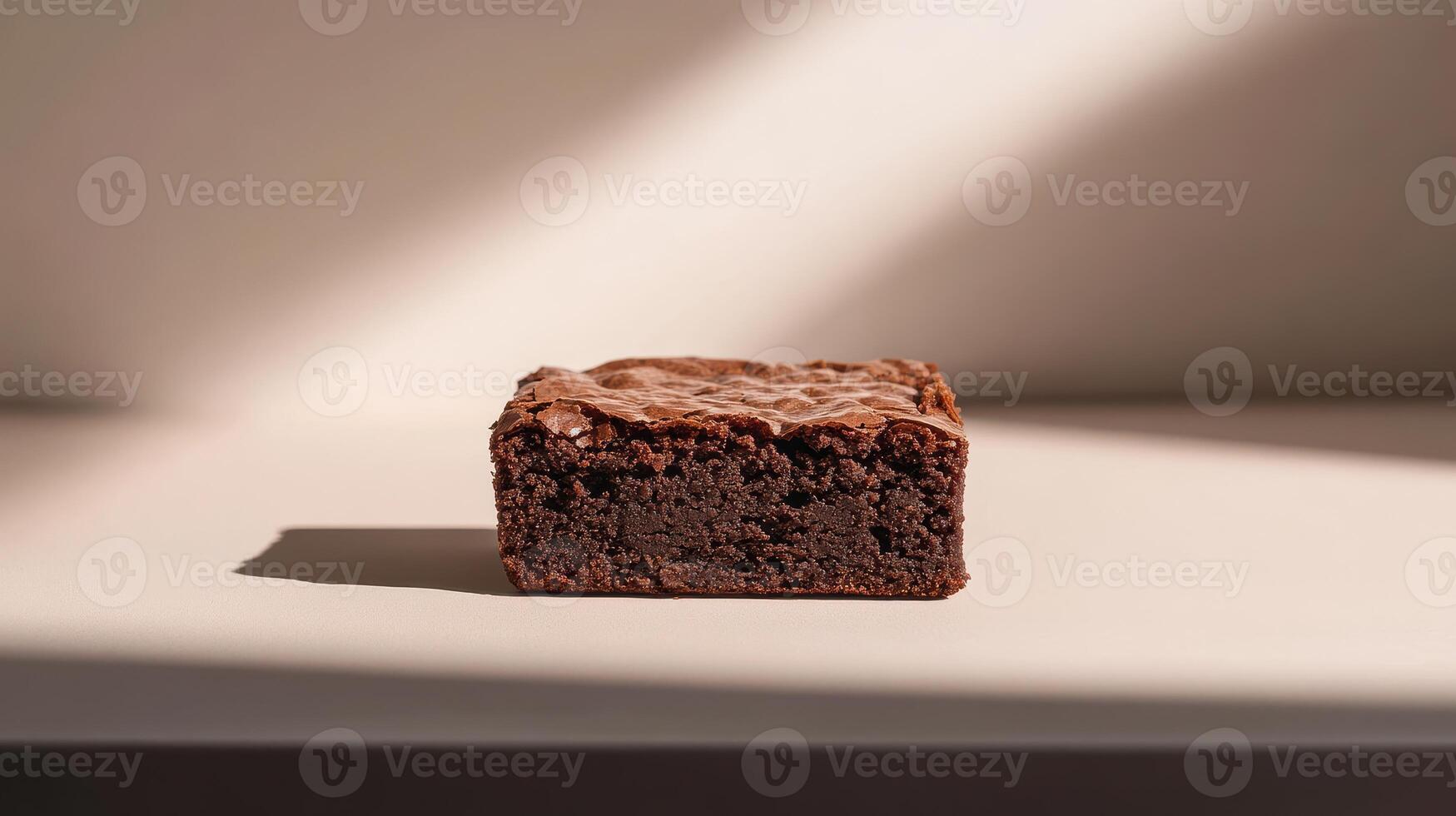 Deliciously rich chocolate brownie on a light surface with soft shadows highlighting its texture photo