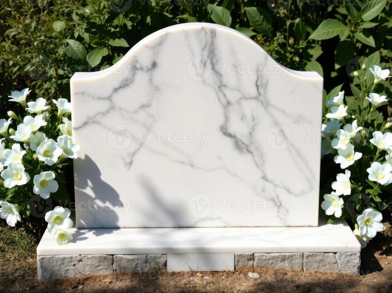 A white marble headstone in front of some flowers photo
