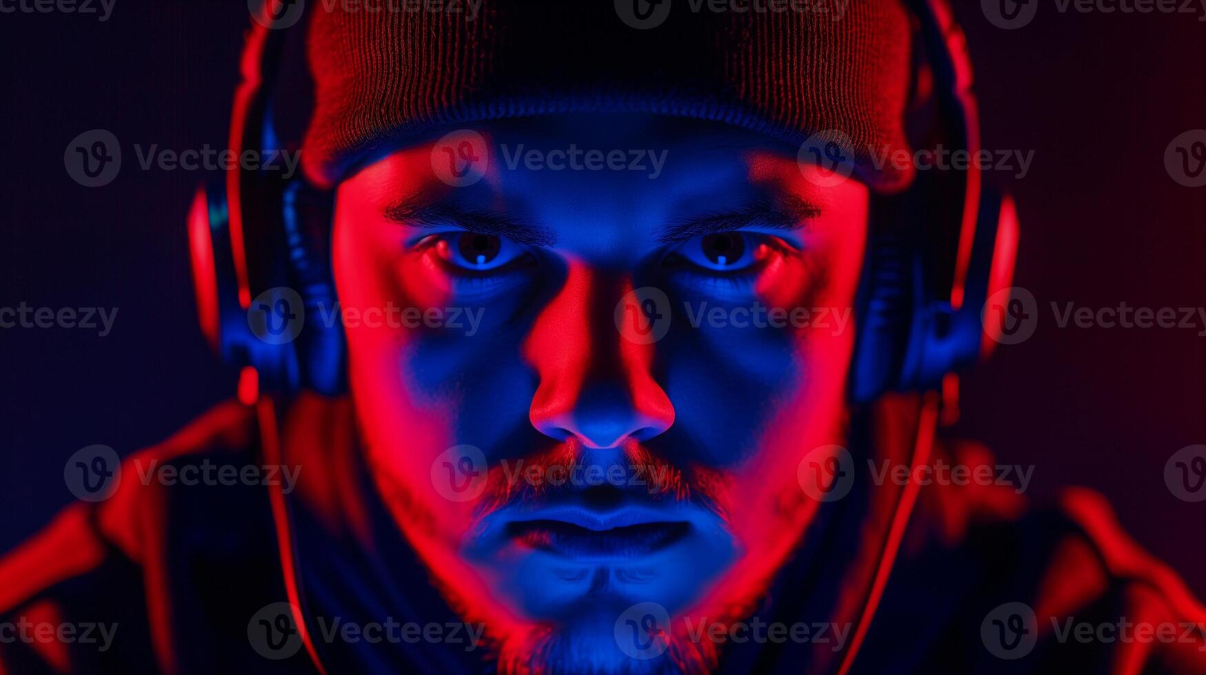 Professional esports player with headphones and beanie image closeup. Intense gamer dramatically lit in vibrant red and blue close-up photography. Cybersport concept photo realistic