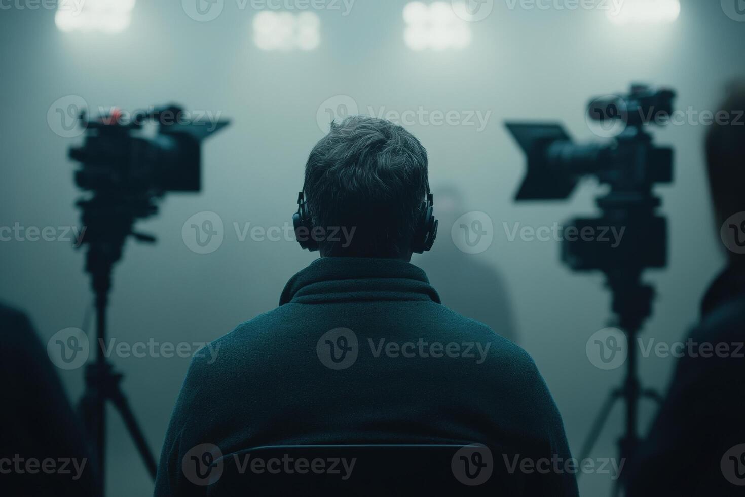 News anchor prepares for a live broadcast amid cameras and dim lighting photo