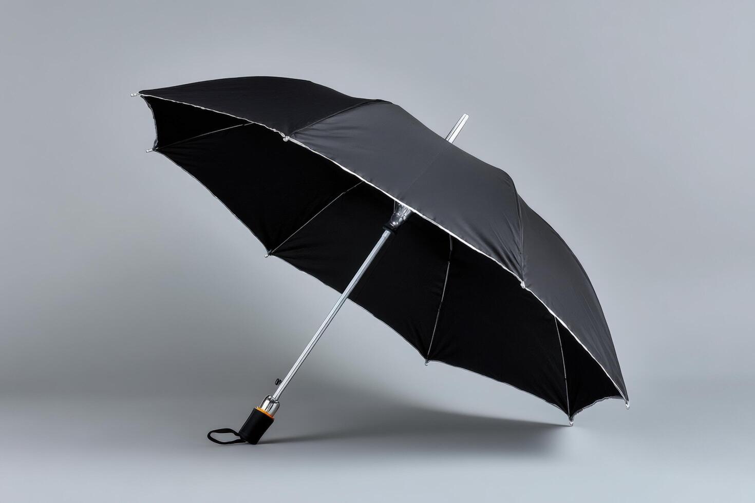 Travel umbrella folded and isolated against a simple grey background for storage or transport photo
