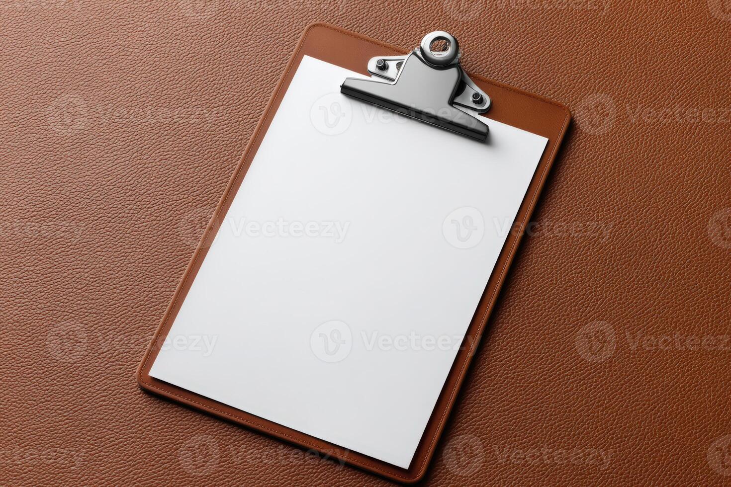 Blank clipboard resting on a textured brown surface waiting for important notes or documents photo