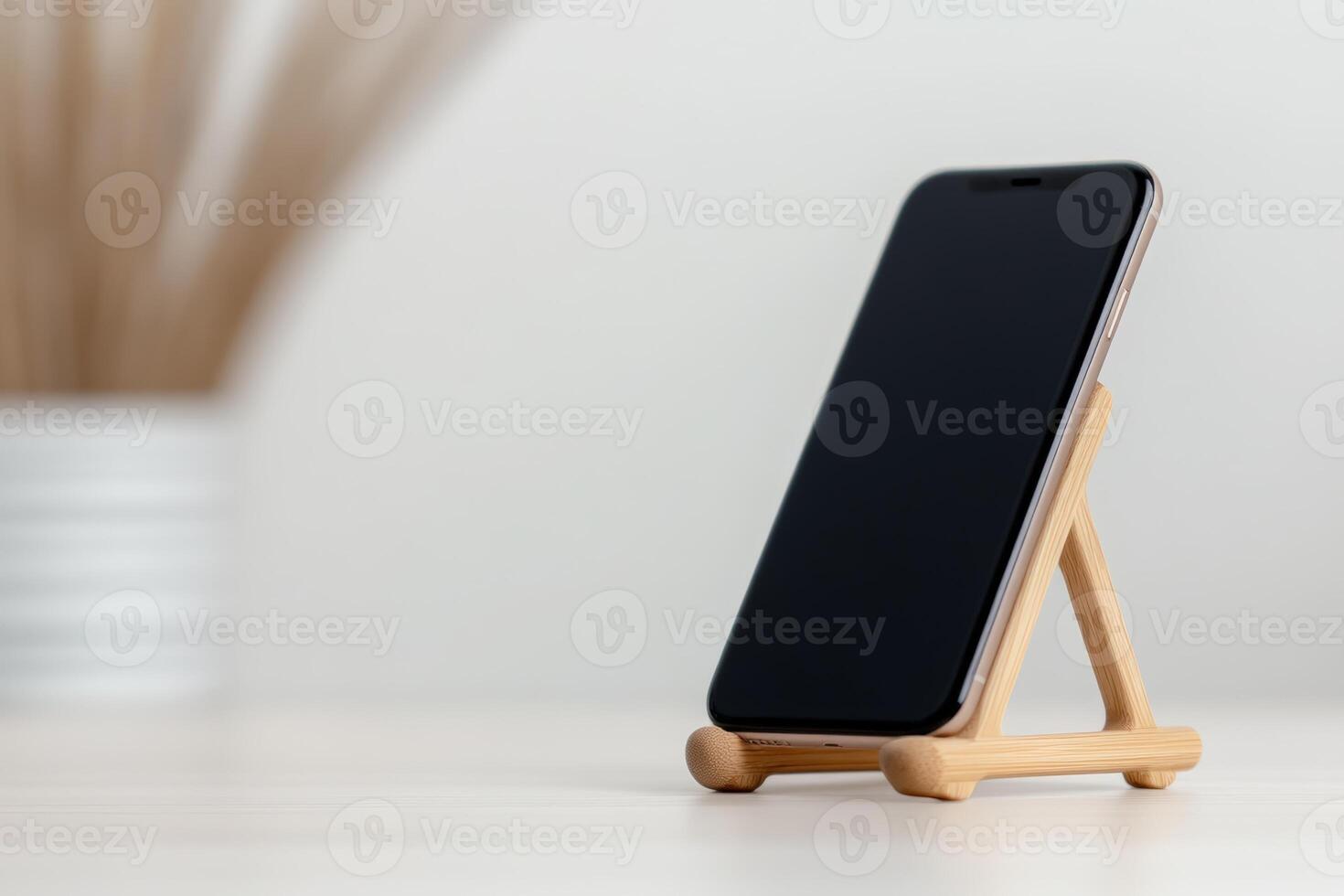 Smartphone displayed on a wooden stand with a modern background in a bright setting photo